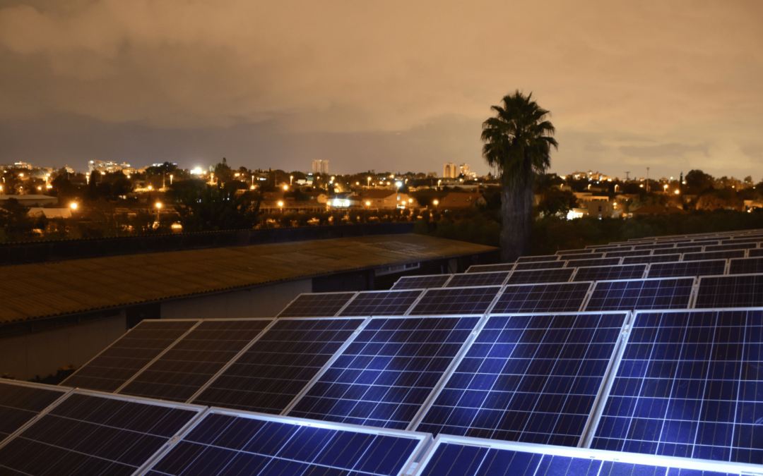 solar panels on a commercial rooftop at night with a cityscape background in orange county, highlighting energy storage solutions for continuous power supply